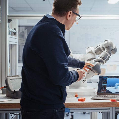 A male scientist adjusts a large microscope in a lab